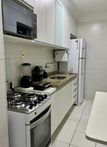 cocina blanca con fogones y nevera en Apartamento - 3 Quartos climatizados - By BellaEstadia, en Aracaju