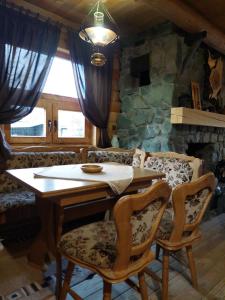 a table and chairs in a room with a stone wall at Apartments Greenstone in Kolašin