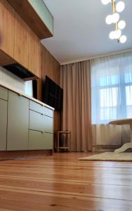 een woonkamer met houten vloeren en een groot raam bij Apartament Staszica 6 in Słupsk