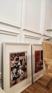 twee ingelijste foto's zittend op de vloer in een kamer bij Apartament Staszica 6 in Słupsk
