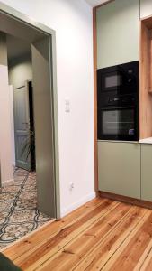 een woonkamer met een keuken en een magnetron bij Apartament Staszica 6 in Słupsk