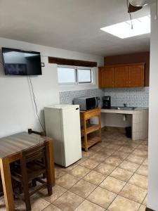 een keuken met een koelkast en een tafel. bij Hotel Jardín del Cantador in Guanajuato
