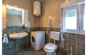 a bathroom with a toilet sink and a washing machine at Apartman Mira in Makarska