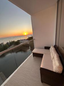 uma varanda com vista para o mar ao pôr-do-sol em EXCLUSIVO APTO CON VISTA Y FRENTE AL MAR em Gaira