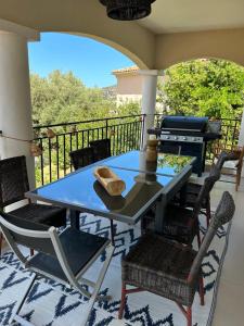 un tavolo e sedie su un balcone con griglia di VILLA U TEMPIU CORSU a Patrimonio