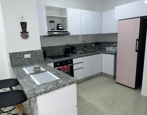 uma cozinha com armários brancos e um balcão de granito em EXCLUSIVO APTO CON VISTA Y FRENTE AL MAR em Gaira