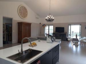 una cucina e un soggiorno con lavandino e orologio di VILLA U TEMPIU CORSU a Patrimonio