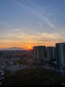 Una puesta de sol sobre una ciudad con edificios y coches. en Green Velvet Studio, en Brasov