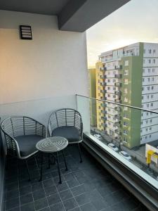 2 sillas y una mesa en un balcón con un edificio en Green Velvet Studio, en Brasov