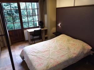a bedroom with a bed and a desk and a window at AP3 - 1dorm privado próx Garten Shop-Universidades in Joinville