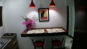 una mesa con dos sillas y un jarrón con flores en AP2-Studio privado próx Garten Shopp-Universidades en Joinville