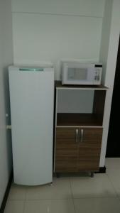 a refrigerator and a microwave on top of a cabinet at AP2-Studio privado próx Garten Shopp-Universidades in Joinville