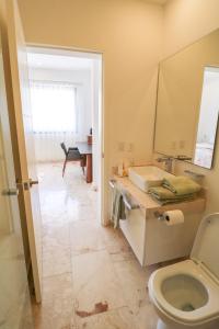 een badkamer met een toilet en een wastafel bij Hermosa Villa en Tulum Country Club acceso a playa in Akumal