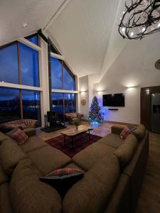 a living room with a large couch and a christmas tree at Waterloo House in Lochinver