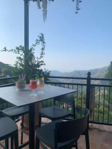 a table and chairs on a balcony with a view at Two Flowers Hotel in Pedoulas
