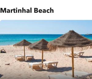 una spiaggia con ombrelloni e sedie e l'oceano di Luxury Apartment with pool in historical town and great surfing beaches a Sagres