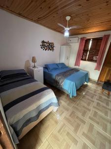 a bedroom with two beds and a wooden ceiling at Hospedaria de Maria in Tiradentes