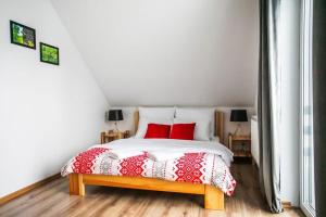 sypialnia z łóżkiem z czerwonymi poduszkami w obiekcie Domki na Snowańcu w Brennie