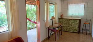 eine Küche mit einer Theke, einem Tisch und einer Arbeitsplatte in der Unterkunft Casa Satori - Recanto de Paz in Alto Paraíso de Goiás