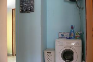 eine Waschküche mit einer Waschmaschine und einer blauen Wand in der Unterkunft Apartment Ombla in Mokošica