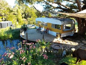 una caravana estacionada en un patio con terraza en Down to earth NZ, en Kerikeri