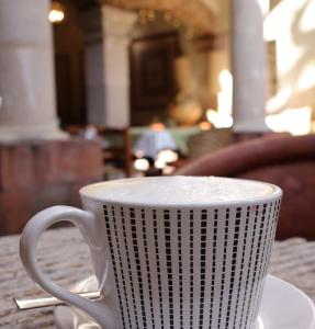 a white coffee cup sitting on a table at Hotel los Arcos in Taxco de Alarcón