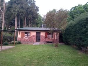 una pequeña casa en un patio con un campo de hierba en Casa de Campo Mama Lucia en 