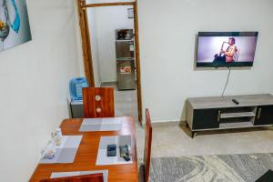 a dining room with a table and a television on a wall at J&J luxury homes in Kericho