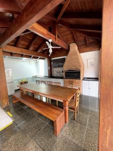 ein Esszimmer mit einem Holztisch und einem Kamin in der Unterkunft Bene Beach - Pousada Guarujá in Guarujá