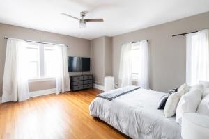 a bedroom with a white bed and two windows at Stylish 3-bd Haven in Trendy Cleveland Heights! in Cleveland Heights