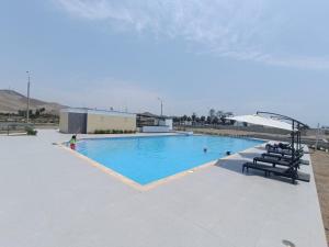 uma grande piscina com pessoas na água em Departamentos de playa em Cerro Azul