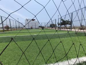 uma cerca em frente a um campo de futebol em Departamentos de playa em Cerro Azul
