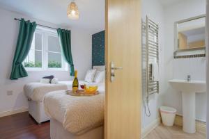 a room with two beds and a sink and a table at Beautiful Apartment - Close to City Centre - Free Parking, Fast Wifi, SmartTV with Sky TV and Netflix by Yoko Property in Northampton