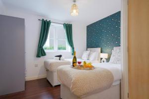 a bedroom with two beds and a table with a bottle of wine at Beautiful Apartment - Close to City Centre - Free Parking, Fast Wifi, SmartTV with Sky TV and Netflix by Yoko Property in Northampton