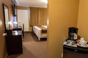 um quarto com um quarto de hotel com uma cama em SKKY Hotel em Whitehorse