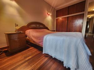 - une chambre avec un lit et une armoire en bois dans l'établissement Departamento 3 ambientes a una cuadra de la playa - La Perla, à Mar del Plata