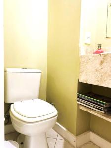 a bathroom with a white toilet and a sink at Charme do Leme in Rio de Janeiro