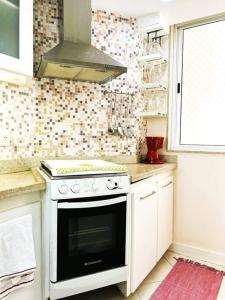 a kitchen with a white stove and a window at Charme do Leme in Rio de Janeiro