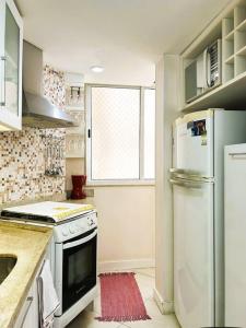 a kitchen with a stove and a refrigerator at Charme do Leme in Rio de Janeiro