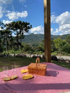 uma mesa de piquenique com uma cesta de piquenique e pães em LOFT.276 - CASA DE CAMPO em Bento Gonçalves