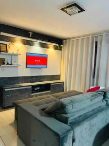 a living room with a couch and a flat screen tv at LOFT.276 - CASA DE CAMPO in Bento Gonçalves