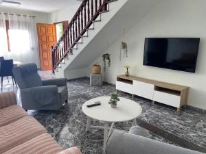 a living room with a couch and a flat screen tv at Casa Costa Molina in Puntallana