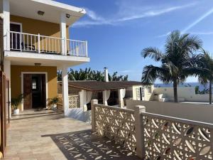 a house with a fence and a balcony and palm trees at Casa Costa Molina in Puntallana