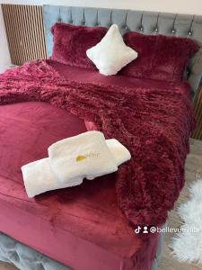 een roze bed met twee handdoeken erop bij Villa Bellevue in Orllan