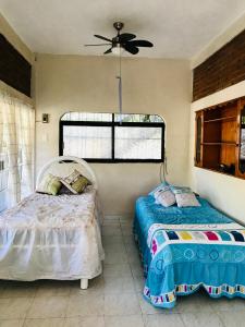 um quarto com 2 camas e uma ventoinha de tecto em Ixtapa Playa Linda Hostel em Barrio Nuevo