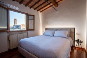 um quarto com uma grande cama branca e uma janela em Panoramic Apartment - A due passi dal centro - Vicino alla Mini Metro Pincetto em Perugia