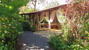 einen Garten mit einem Pavillon inmitten eines Gartens in der Unterkunft Casa Satori - Recanto de Paz in Alto Paraíso de Goiás