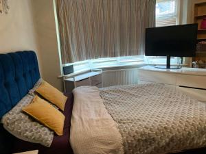 1 dormitorio con 1 cama, TV y ventana en Lovely double bedroom house 1 en Buckinghamshire
