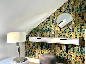 a living room with a mirror and a chair at Midsummer Cottage Cambridge in Chesterton