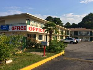 an office building with a parking lot in front of it at Carpet Inn in Opelika